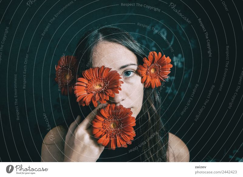 a girl with blue eyes and long hair covering herself with a gerbera flower Lifestyle Beautiful Face Relaxation Calm Human being Feminine Young woman