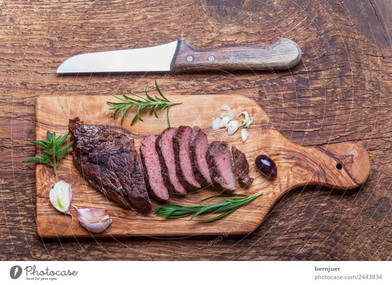 Slices of a grilled steak on wood Food Meat Herbs and spices Media Barbecue (apparatus) Wood Authentic Steak Beef board Knives Blade boil BBQ Ribeye supervision