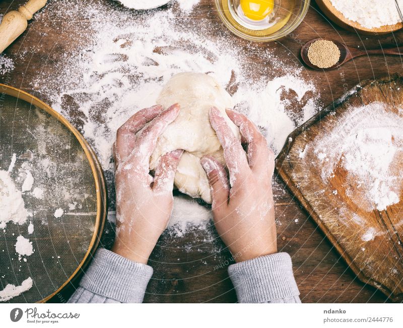 female hands knead a dough Dough Baked goods Bread Bowl Table Kitchen Arm Hand Sieve Wood Fresh Natural Above Brown White Yeast background Preparation food