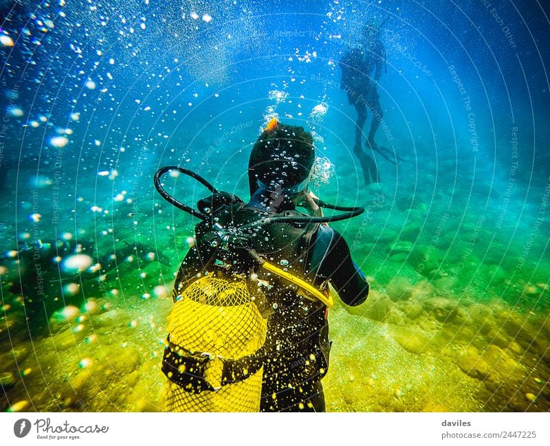Man in his back with scuba diving equipment exploring the ocean floor. Lifestyle Leisure and hobbies Vacation & Travel Adventure Ocean Sports Aquatics Dive