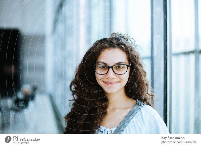cute brazilian girl with curly hair and casual clothing smiles for the camera attractive beautiful clever ethnicity exited expression eyeglasses face female