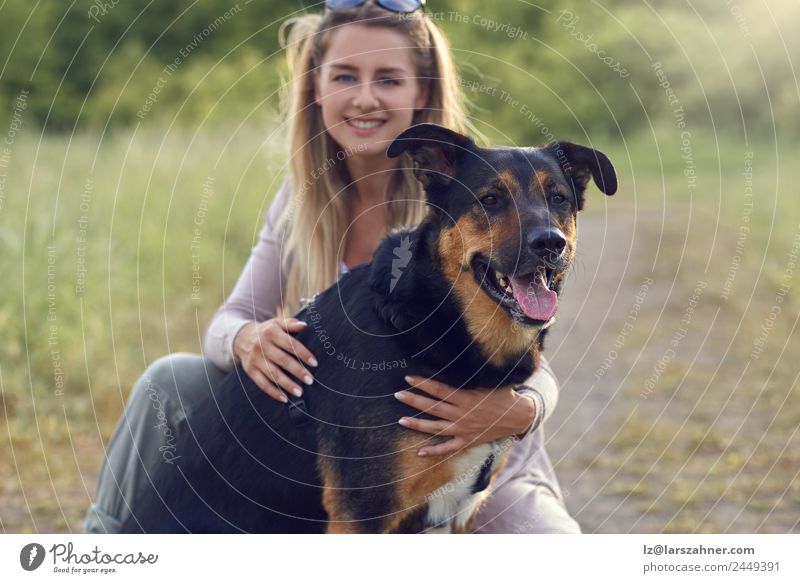 Pretty blond woman with her two dogs Happy Face Summer Woman Adults Friendship 1 Human being 18 - 30 years Youth (Young adults) Animal Warmth Grass Meadow
