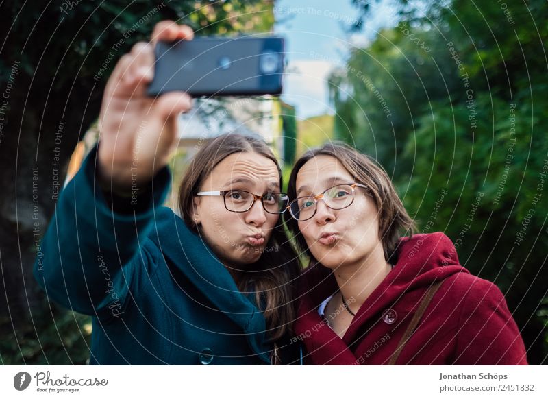 funny twin sisters make a selfie with the smartphone Lifestyle Joy luck Human being Feminine Young woman Youth (Young adults) Brothers and sisters Sister 2