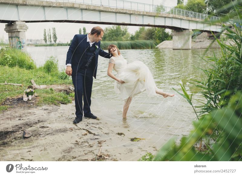 the groom holds a smiling bride who wets her feet in the river Lifestyle Leisure and hobbies Summer Waves Valentine's Day Wedding Masculine Feminine Young woman