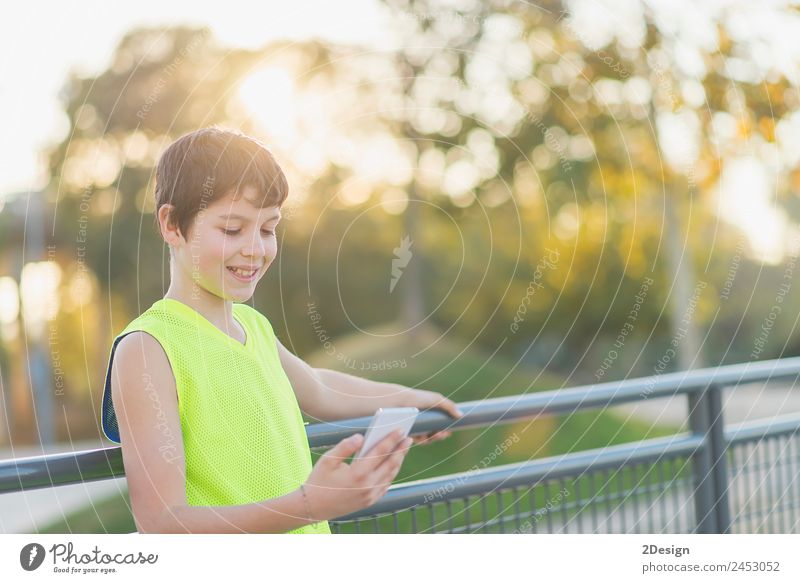teenager smiling looking his smartphone on a basketball court Lifestyle Style Joy Happy Leisure and hobbies Decoration School Academic studies Telephone