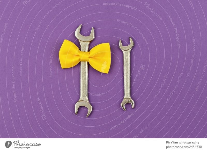 Two wrench large and small with yellow tied bow on violet Lifestyle Design Happy Decoration Feasts & Celebrations Birthday Tool Masculine Man Adults Parents