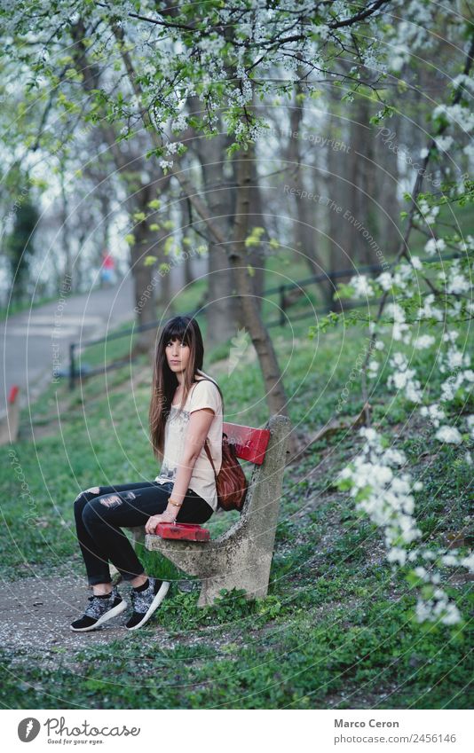 Young woman sitting on a bench in a park in serene pose Lifestyle Beautiful Hair and hairstyles Healthy Relaxation Calm Vacation & Travel Summer Human being