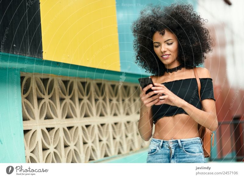 Woman with afro hair on the street holding a smart phone Lifestyle Style Joy Happy Beautiful Hair and hairstyles Telephone PDA Technology Human being Feminine