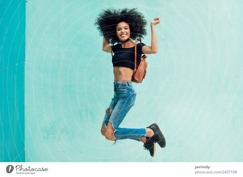 Young mixed woman with afro hair jumping outdoors. Lifestyle Style Happy Hair and hairstyles Face Human being Woman Adults 1 18 - 30 years Youth (Young adults)