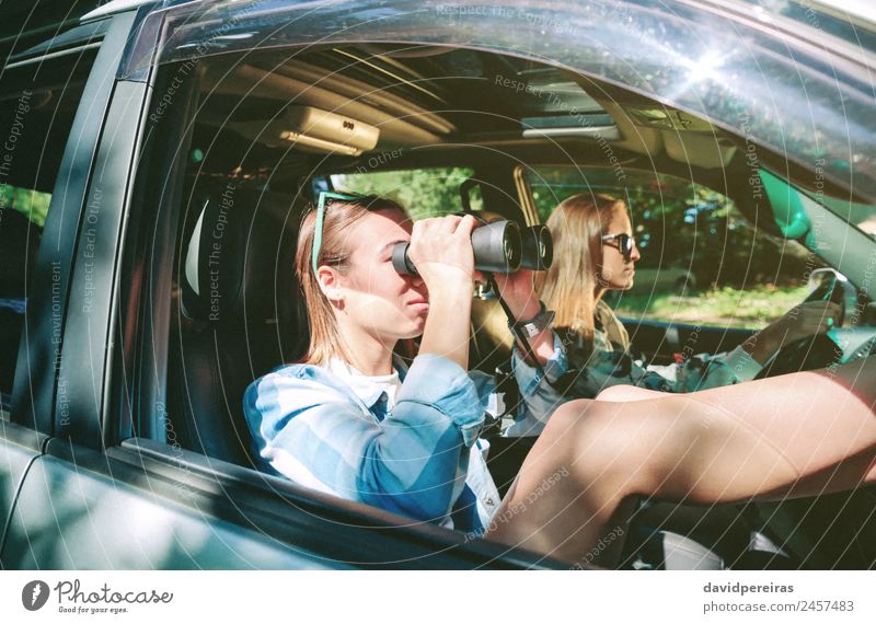 Woman looking through the binoculars and friend driving Lifestyle Happy Beautiful Relaxation Leisure and hobbies Vacation & Travel Trip Human being Adults