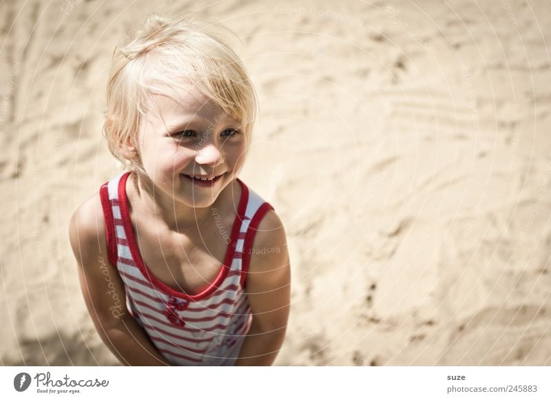 little girl with light hair standing in a swimsuit in the summer