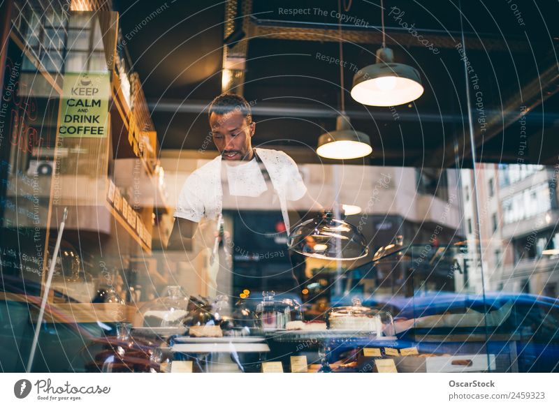 African man works in pastry shop. Dessert Breakfast Happy Work and employment Business Man Adults Smiling Fresh Small Delicious Black Self-confident Pride