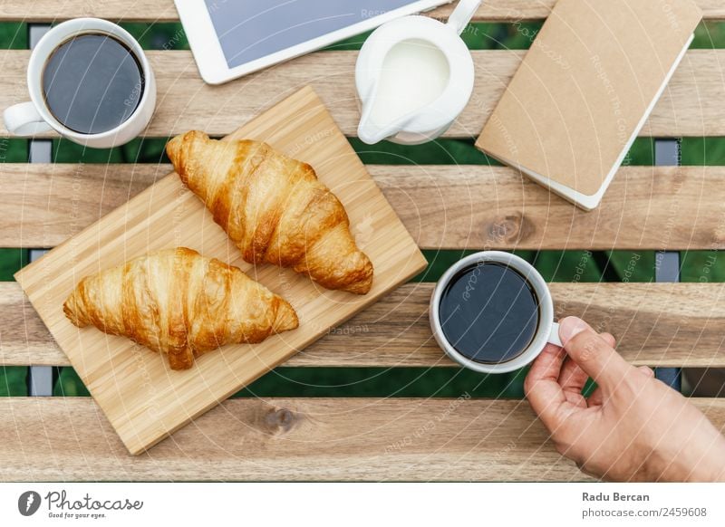 Morning Breakfast In Green Garden With French Croissant, Coffee Cup, Orange Juice, Tablet and Notes Book On Wooden Table Background picture White Food Drinking