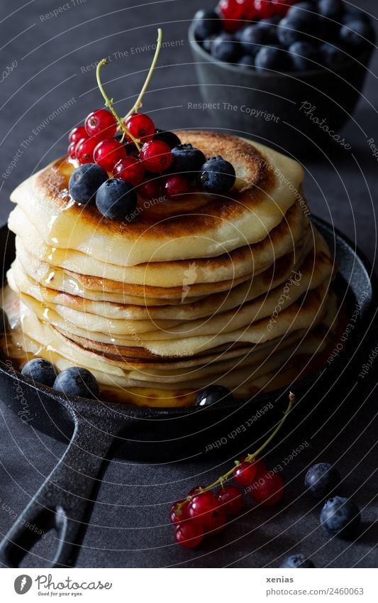 Sweet pancakes with currants, blueberries and delicious maple syrup in a cast-iron black pan Pancake Food sugar syrup Redcurrant fruit Dough Baked goods