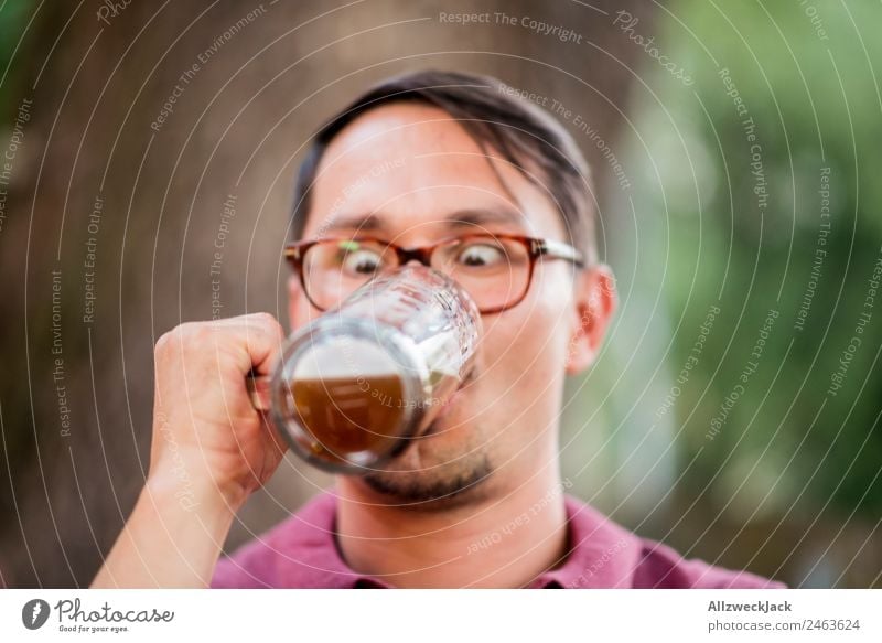 Portrait of a young man with a beer glass in his hand Portrait photograph 1 Person Young man Upper body Looking Inattentive drinking contest Beer glass Beer mug
