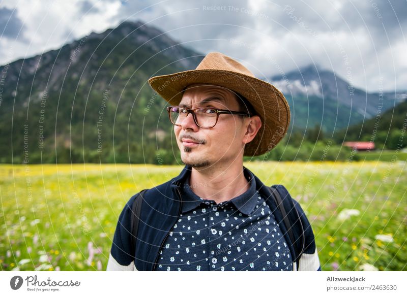 young man with hat in front of mountain panorama Day Beautiful weather Clouds Nature Green Tree Forest Mountain Idyll Vacation & Travel Travel photography