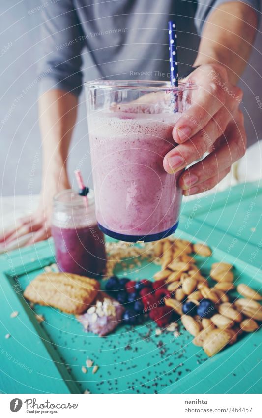 Man holding a milkshake of berries and oat flakes Fruit Dessert Berries Almond Cookie Breakfast Organic produce Vegetarian diet Beverage Drinking Cold drink