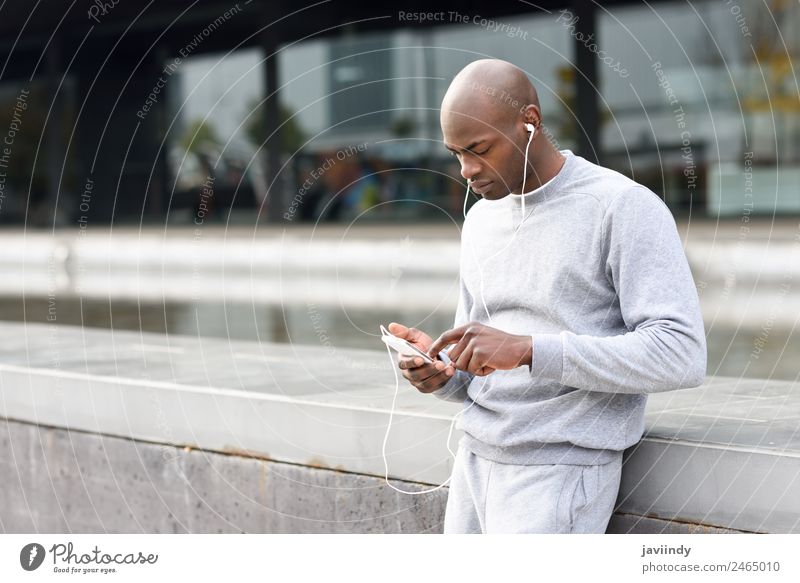 Attractive black man listening to music with earphones Lifestyle Happy Music Sports Telephone PDA Technology Human being Masculine Young man