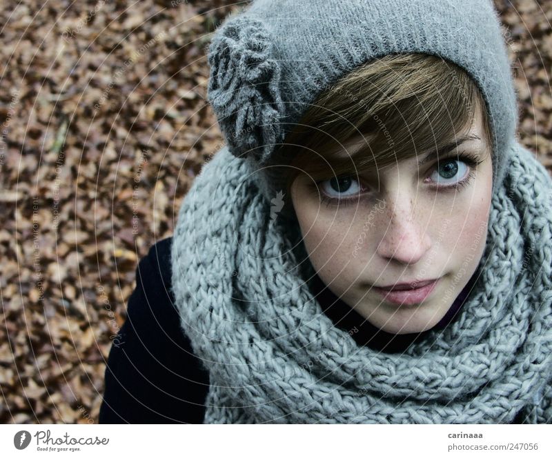 Portrait of a young woman in winter clothes and a hat wrapped in a scarf  with a big smile - a Royalty Free Stock Photo from Photocase