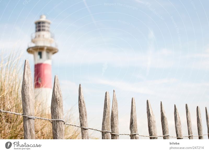 lighthouse romance Grass Coast North Sea Deserted Tower Lighthouse Tourist Attraction Landmark Blue Red White Wanderlust Safety Fence Wooden stake Dune