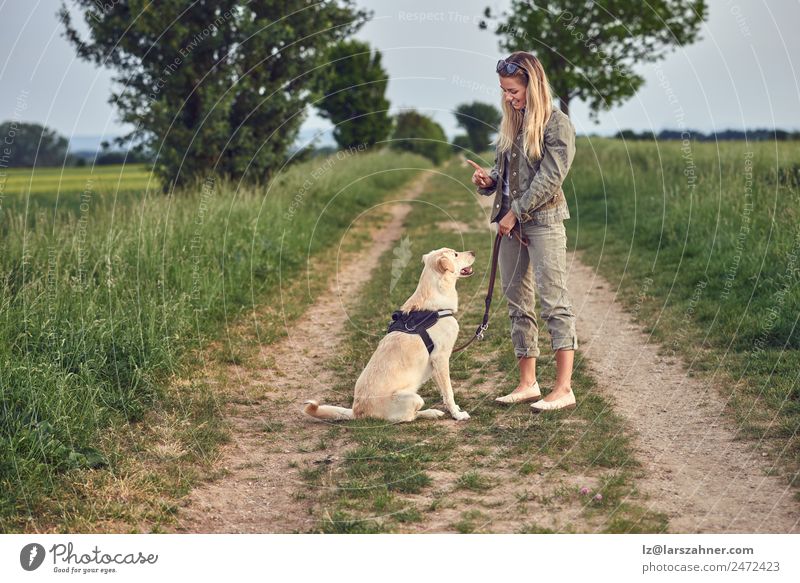 Attractive young woman teaching her dog Summer Woman Adults Friendship 1 Human being 18 - 30 years Youth (Young adults) Landscape Animal Lanes & trails Blonde