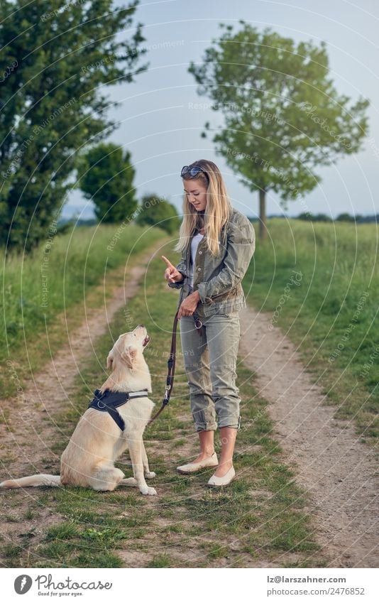 Attractive young woman teaching her dog Summer Woman Adults Friendship 1 Human being 18 - 30 years Youth (Young adults) Landscape Animal Lanes & trails Blonde