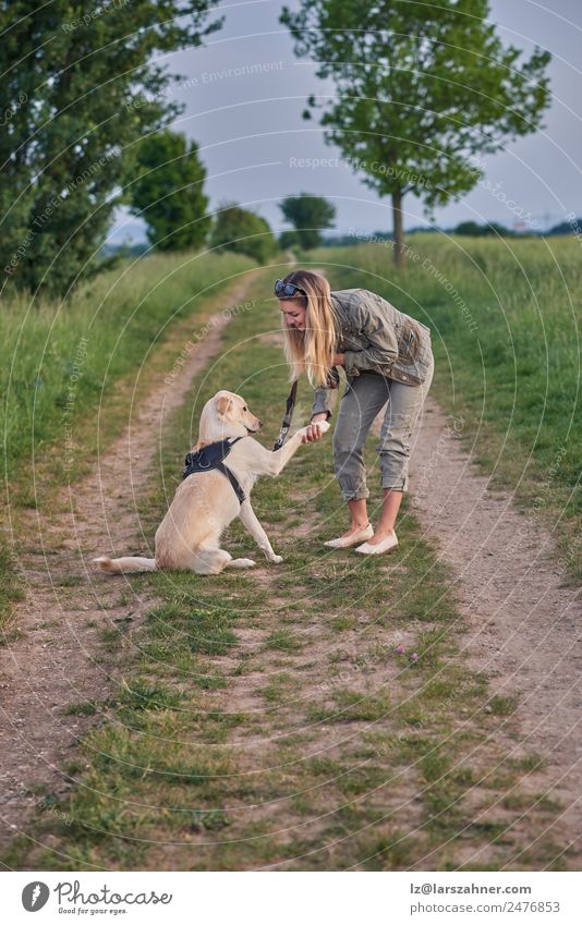 Loving young woman offered a paw by her dog Summer Woman Adults Friendship 1 Human being 18 - 30 years Youth (Young adults) Landscape Animal Lanes & trails