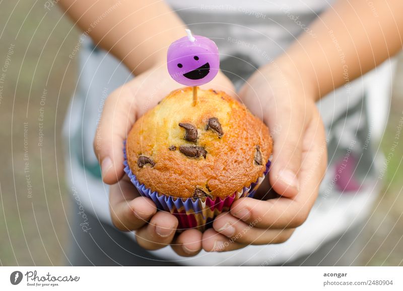 Cupcake and candle smiling in the hands of a child. Dessert Happy Table Birthday Child Gastronomy Boy (child) Hand Paper Candle Smiling Delicious Baking