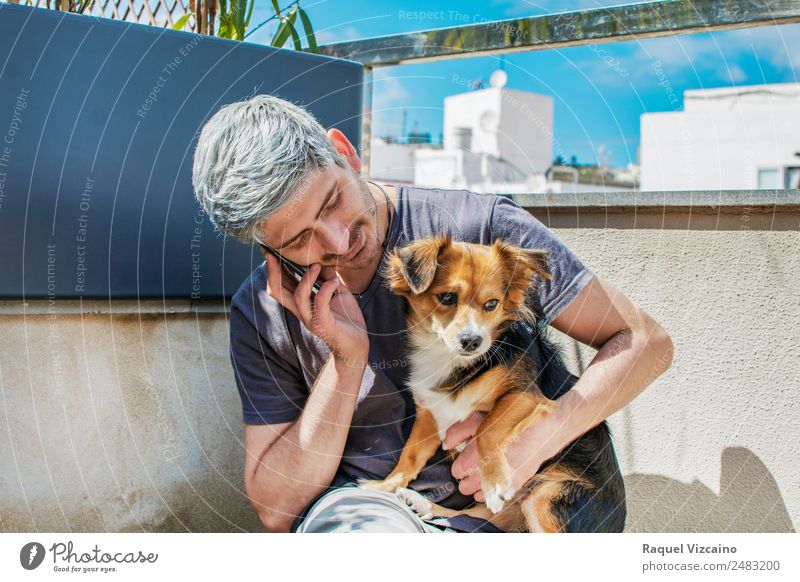 Young man talking on the phone while caressing his dog Cellphone Masculine Man Adults Face Arm 1 Human being 18 - 30 years Youth (Young adults) Garden Animal