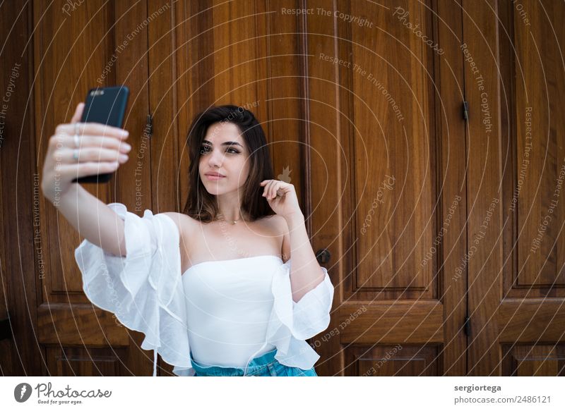 Lovely trendy young woman taking selfie Elegant Style Beautiful Calm Leisure and hobbies Summer PDA Technology Woman Adults Clothing Brunette Wood Stand
