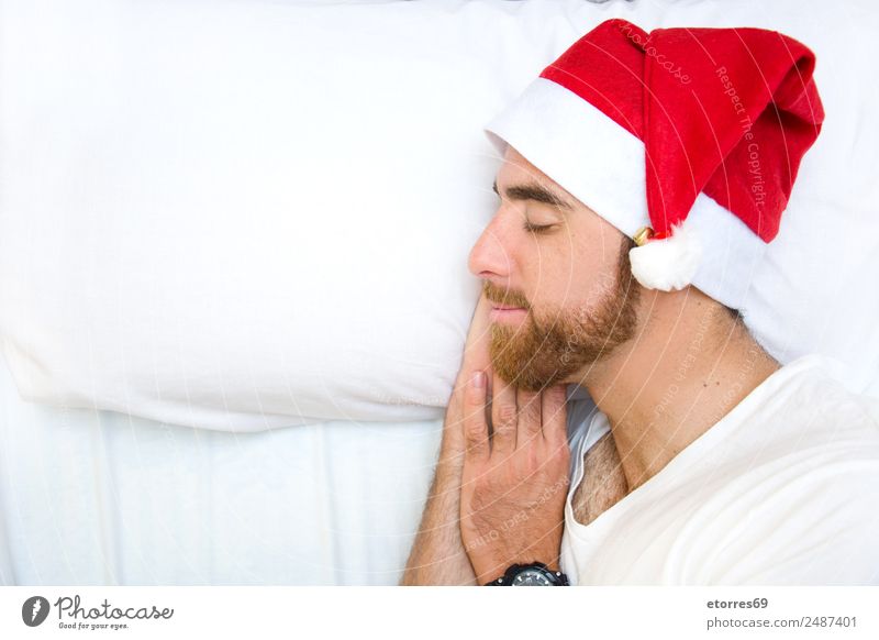 Young man with Santa hat sleeping in bed. Copyspace left. Party Feasts & Celebrations Christmas & Advent Human being Masculine Youth (Young adults) Face