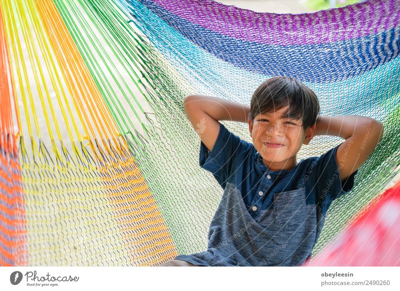 The little boy sitting at the hammock and he so happy Lifestyle Joy Happy Relaxation Leisure and hobbies Vacation & Travel Summer Garden Child Human being