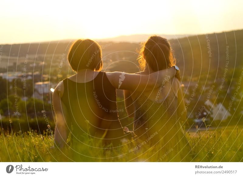 2 young women sitting on the meadow looking into the distance Leisure and hobbies Freedom Summer Human being Woman Adults Brothers and sisters Sister Friendship