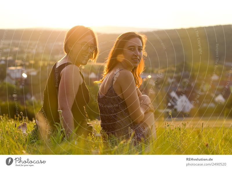 Two women sitting on a meadow in the evening light Lifestyle Human being Young woman Youth (Young adults) Woman Adults Brothers and sisters Sister Friendship 2