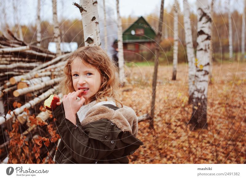 happy funny kid girl eating fresh apple in autumn Fruit Apple Lifestyle Joy Happy Playing Knit Garden Child Infancy Nature Autumn Warmth Leaf Forest Scarf