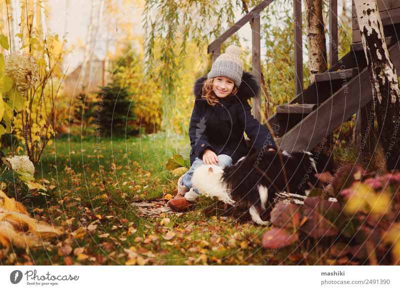 autumn portrait of happy kid girl playing with her dog Lifestyle Joy House (Residential Structure) Garden Child Friendship Nature Autumn Coat Hat Pet Dog Wood
