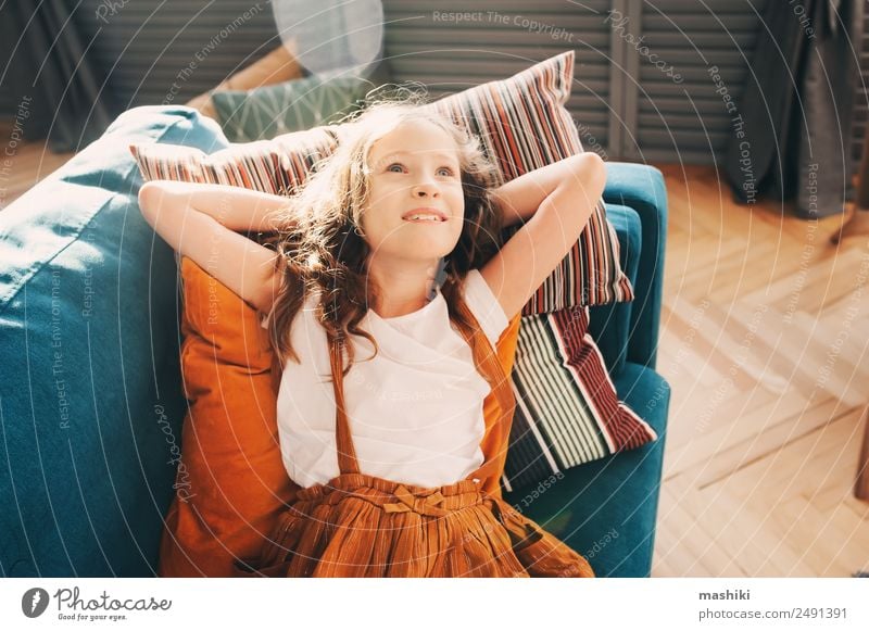 happy kid girl relaxing on cozy couch in modern living room. Lifestyle Happy Flat (apartment) House (Residential Structure) Moving (to change residence)