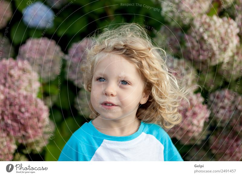 Cute Small Child With Long Hair In The Garden A Royalty Free