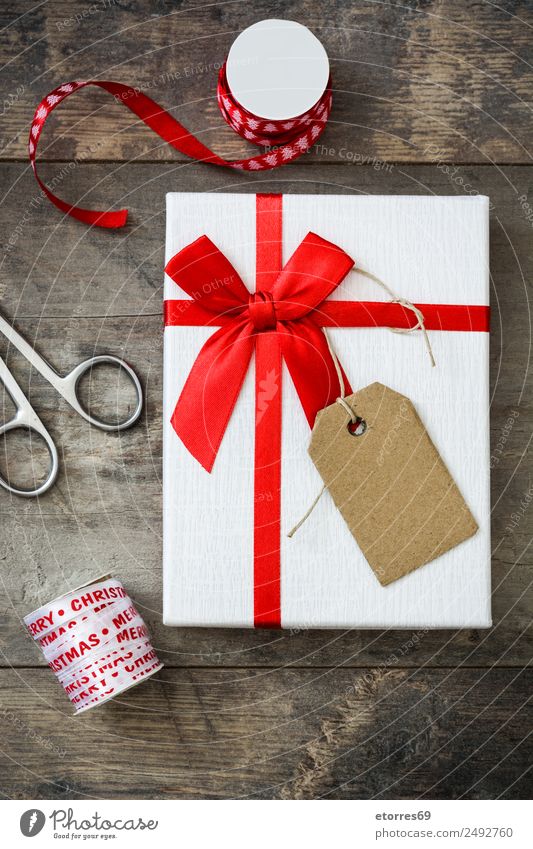 Gift boxes, packing paper, scissors, ribbon on red background