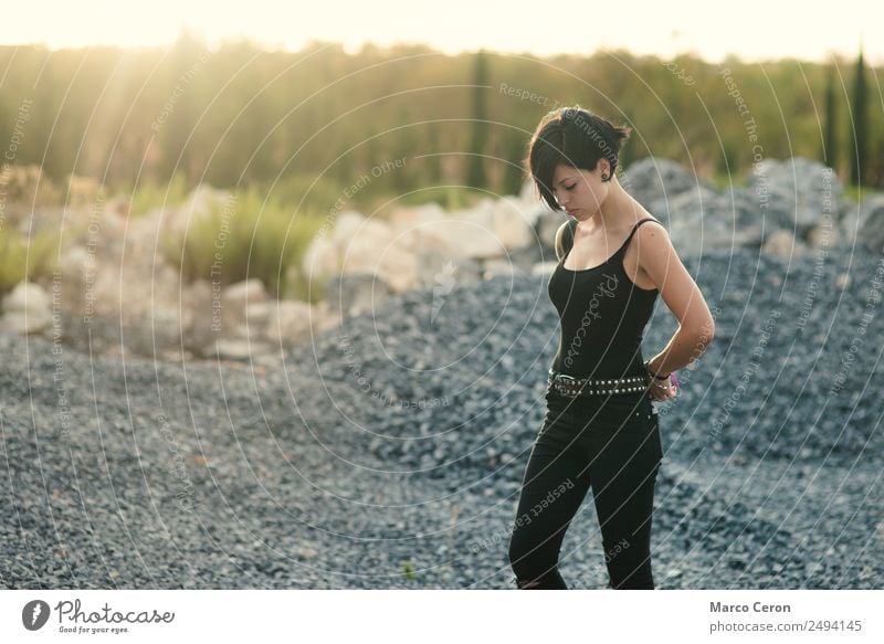 beautiful girl with short haircut and wearing black clothes in countryside enjoying the sunset attractive background breathing caucasian day dreaming fashion