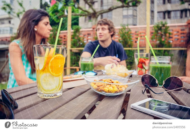 Infused fruit water cocktails and people talking in background Vegetable Fruit Diet Beverage Juice Leisure and hobbies Summer Table To talk Woman Adults Man