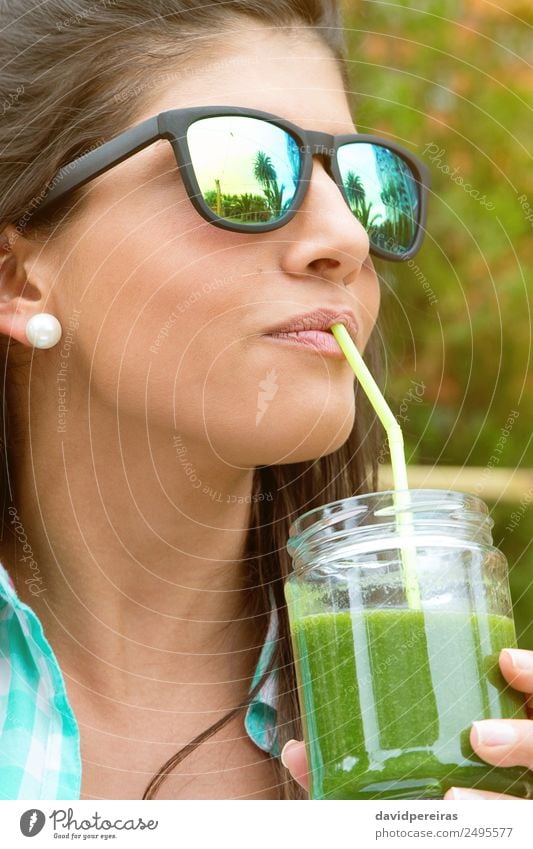 Woman with sunglasses drinking green vegetable smoothie outdoors Vegetable Fruit Nutrition Diet Beverage Juice Lifestyle Happy Beautiful Summer Garden