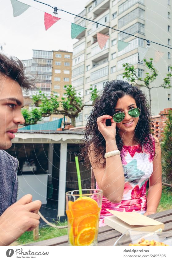 Smiling young woman looking at camera over sunglasses Fruit Beverage Tea Lifestyle Joy Happy Face Leisure and hobbies Summer Table Human being Woman Adults Man