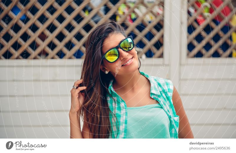 Woman with sunglasses looking at camera over garden fence Lifestyle Joy Happy Beautiful Face Leisure and hobbies Summer Garden Mirror Human being Adults Fingers