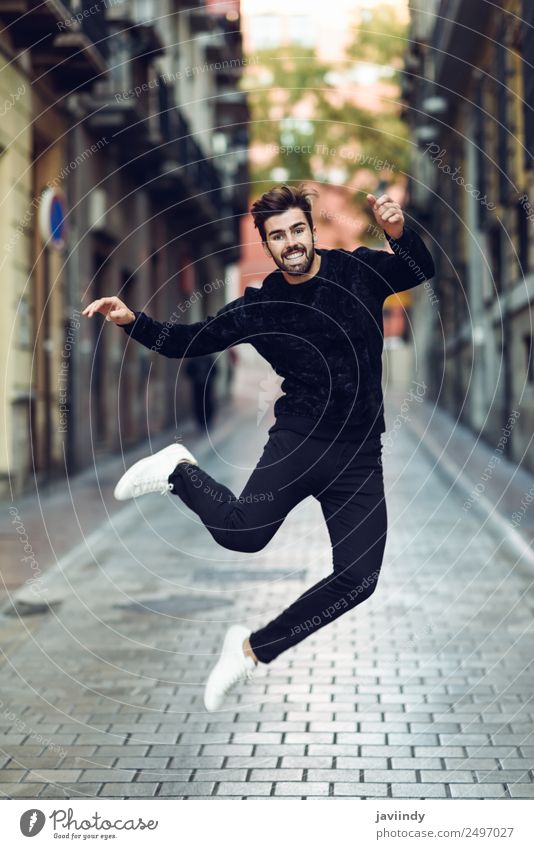 Young bearded man jumping in urban street Lifestyle Joy Human being Masculine Young man Youth (Young adults) Man Adults 1 18 - 30 years Street Fashion Sweater