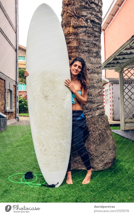 Surfer woman with bikini and wetsuit holding surfboard Lifestyle Joy Happy Beautiful Vacation & Travel Summer Beach Garden Sports Human being Woman Adults Tree