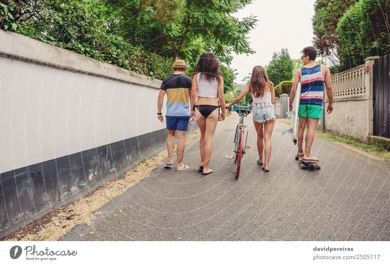 back view of young stylish people walking by industrial district Stock  Photo by LightFieldStudios