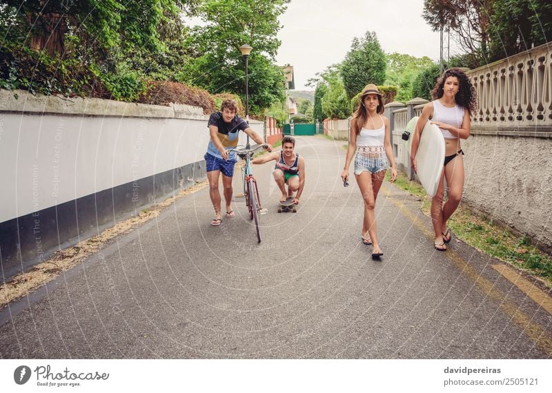 Happy young people having fun with skateboard and bicycle Lifestyle Joy Relaxation Leisure and hobbies Vacation & Travel Summer Sports Woman Adults Man