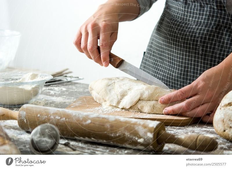 Woman cutting bread dough on wooden table Bread Dough Make kneading Hand Kitchen Apron Flour Yeast Home-made Baking Human being Preparation Stir Ingredients