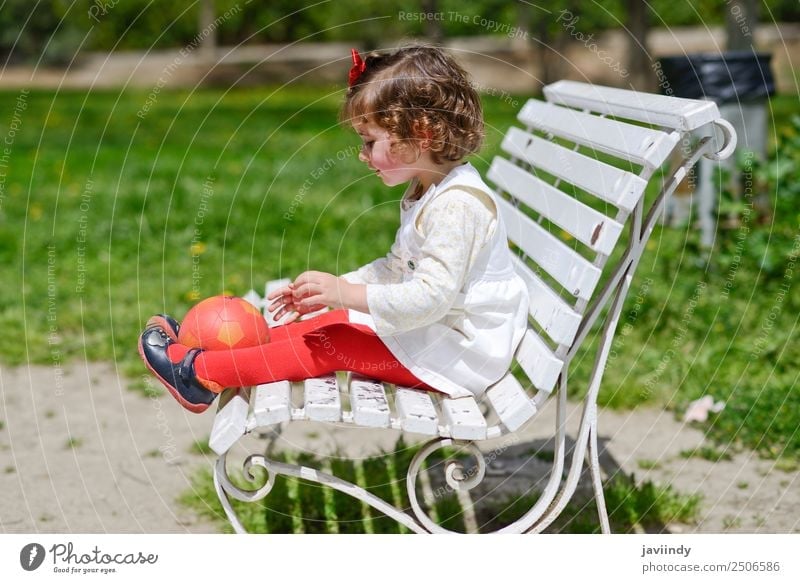 Adorable little girl playing with a ball sitting on a park bench Lifestyle Joy Happy Beautiful Face Summer Child Human being Toddler Girl Woman Adults Infancy 1